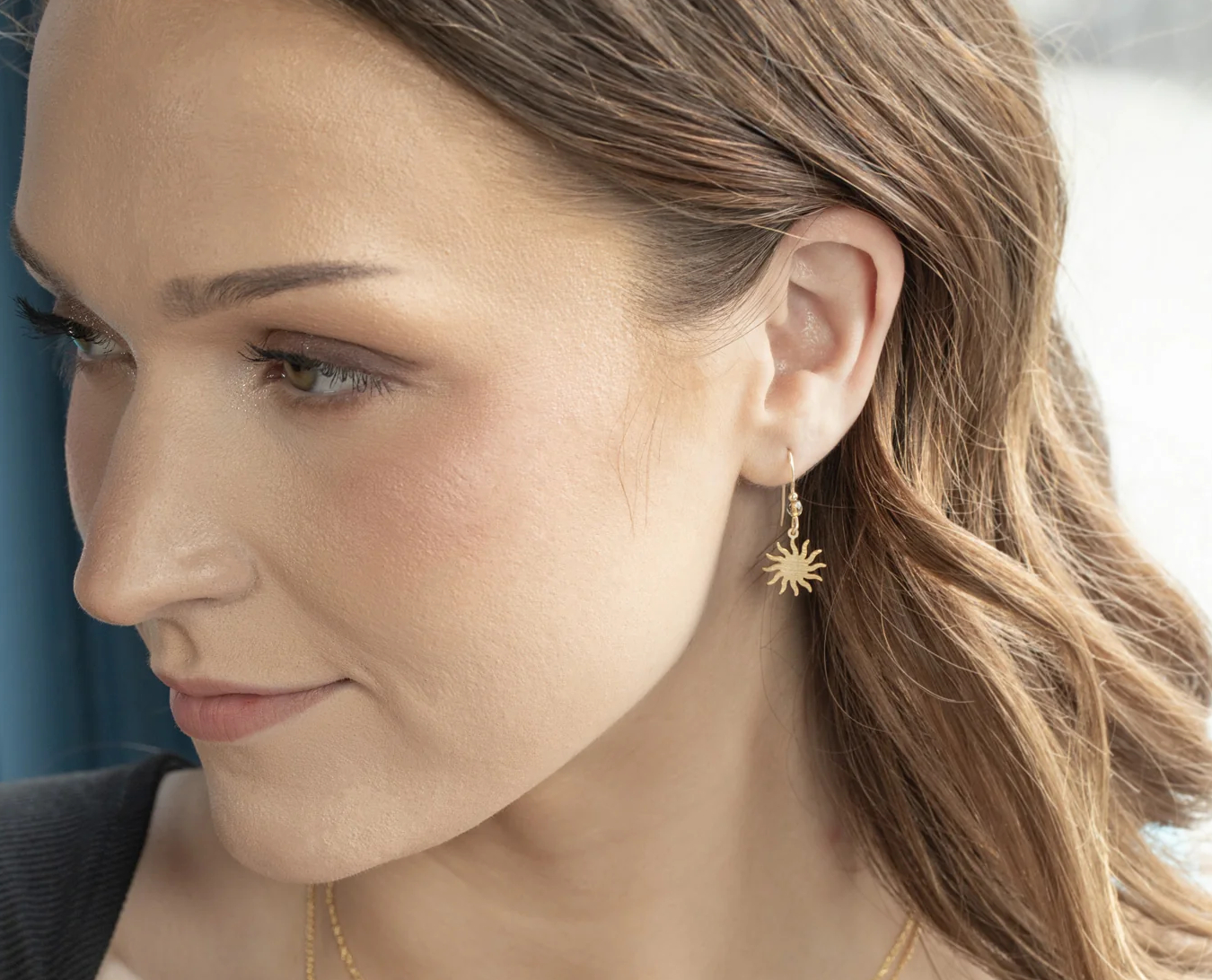 goldtone sun and moon earrings on model