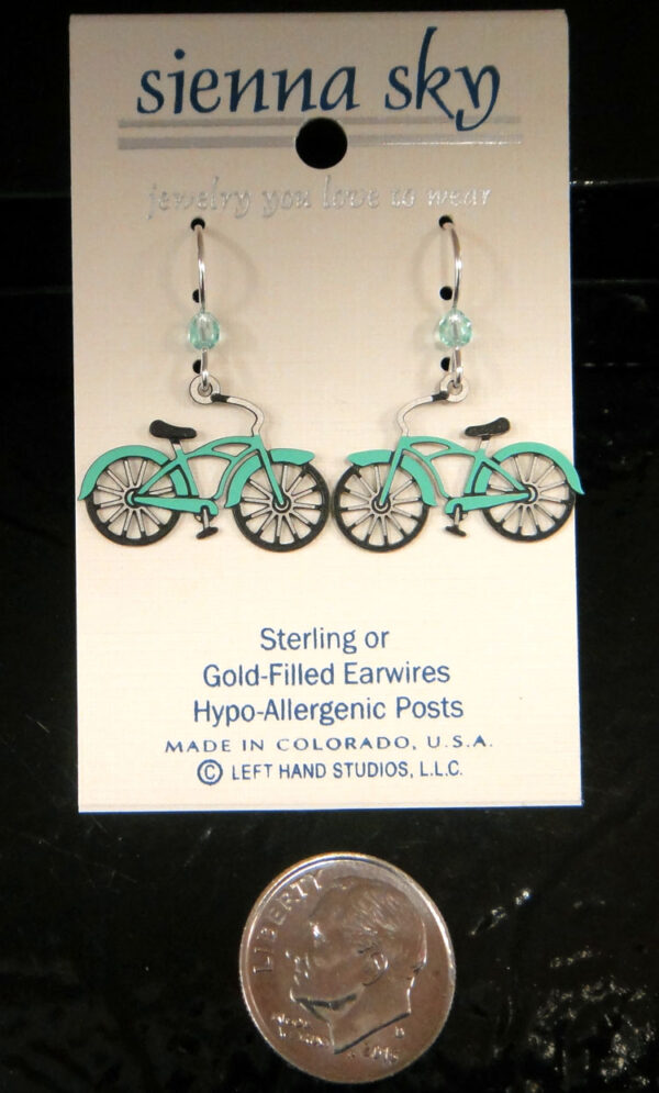 These light blue bicycle earrings are handmade by Sienna Sky and pictured with a dime for scale.