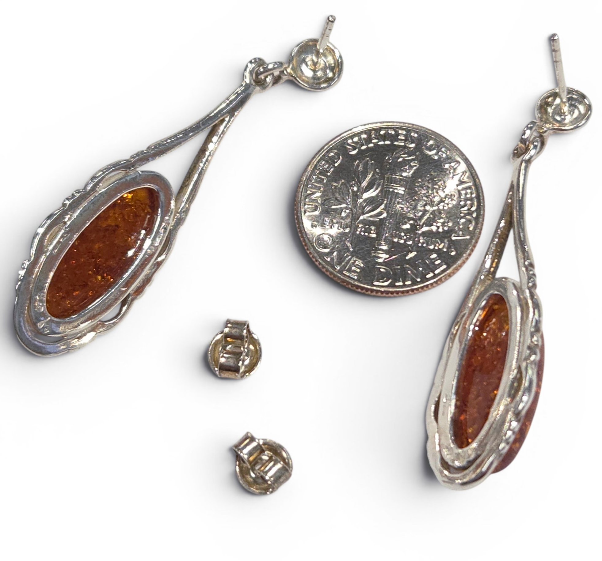 backside of amber earrings with dime for size comparison