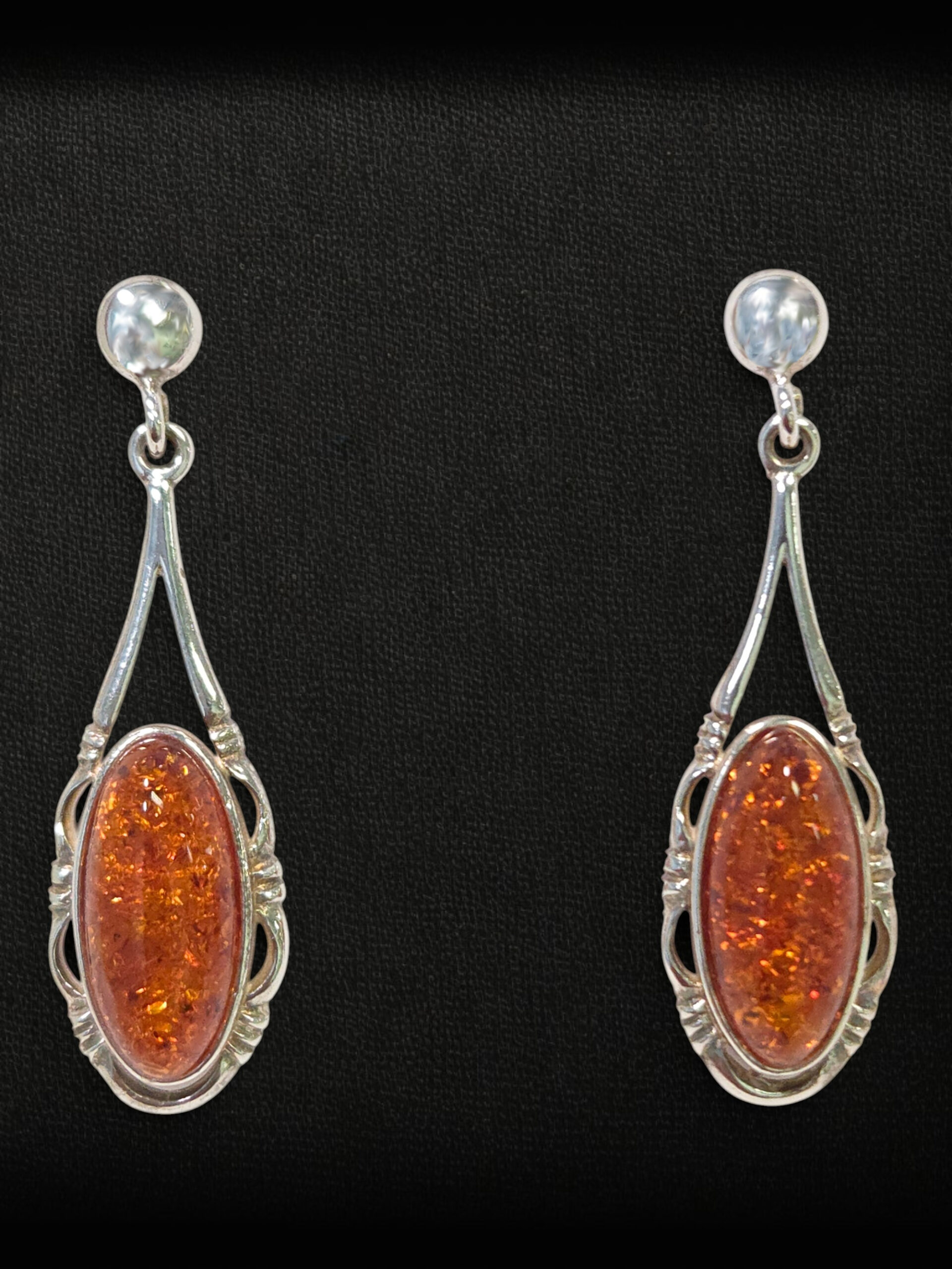 amber earrings on black background