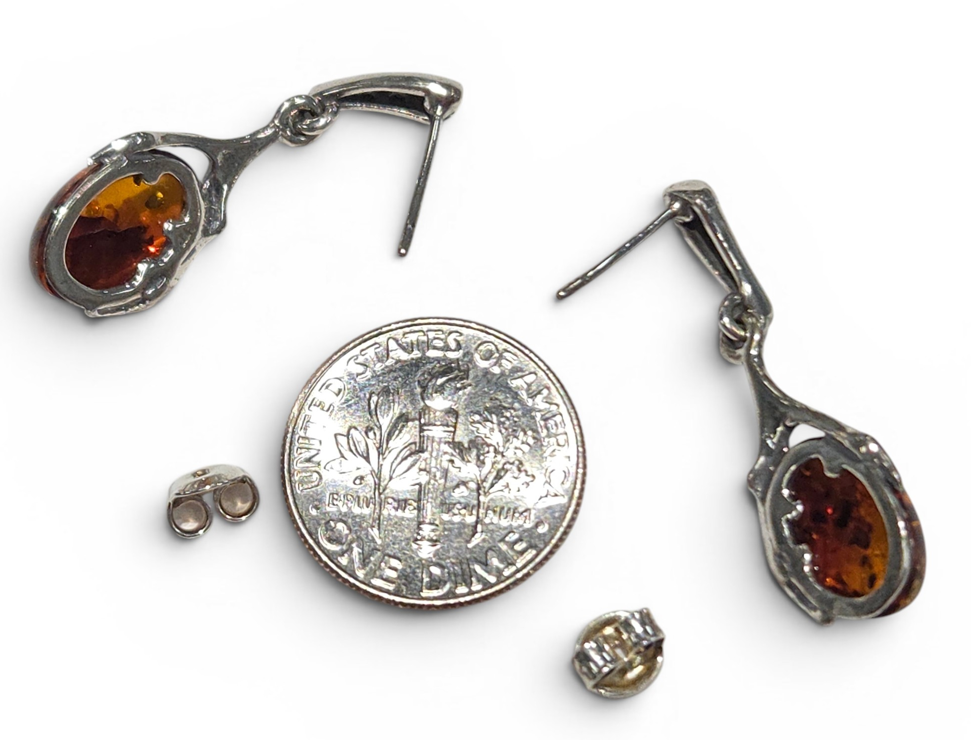 backside of amber earrings with dime for size comparison