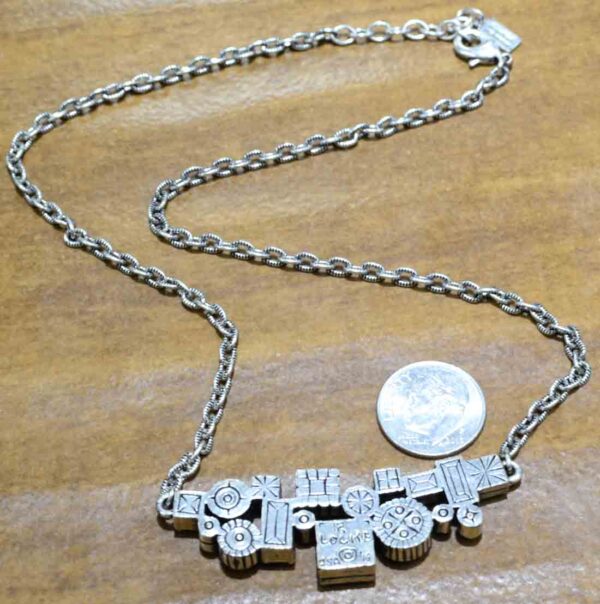 back of Madison Avenue necklace by Patricia Locke with dime for size