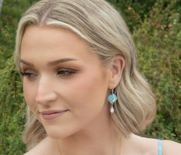 Blue floral earrings on model