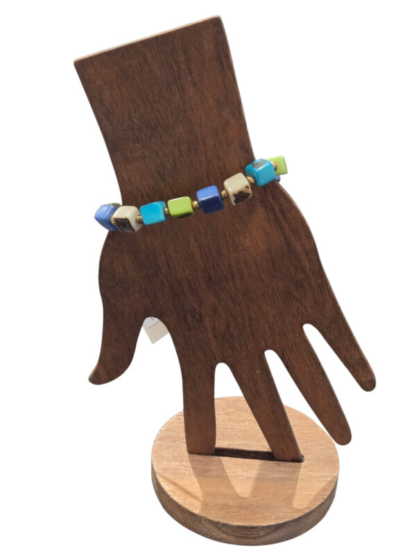beaded tagua nut blue and green cube bracelet on wooden hand form