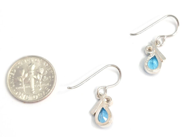 backside of blue topaz, pearl, and sterling silver earrings with dime for size comparison