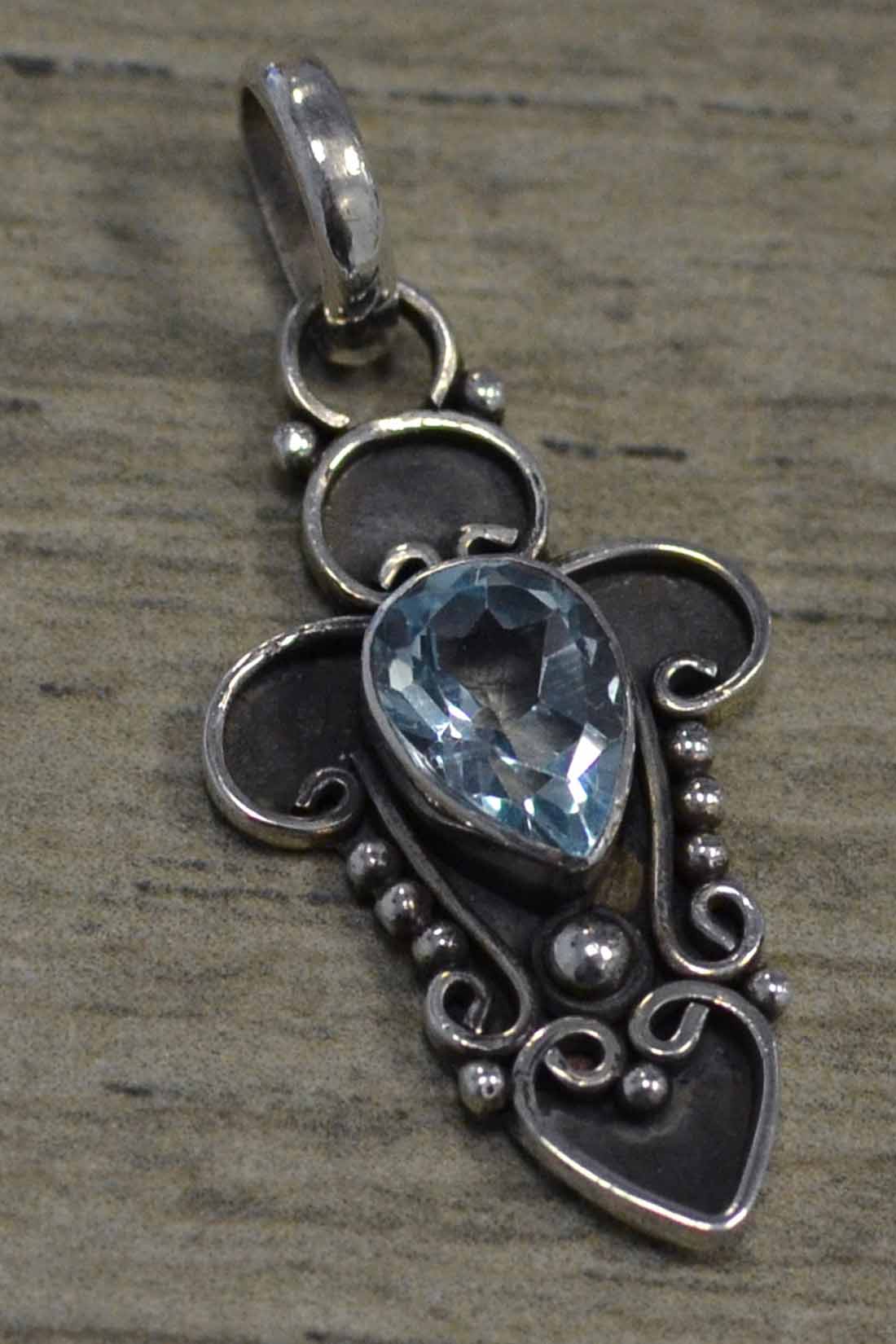 handmade blue topaz and silver swirl design pendant