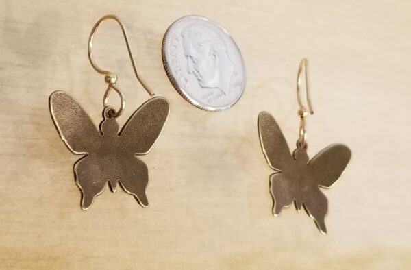 back of butterfly dangle earrings with dime for scale