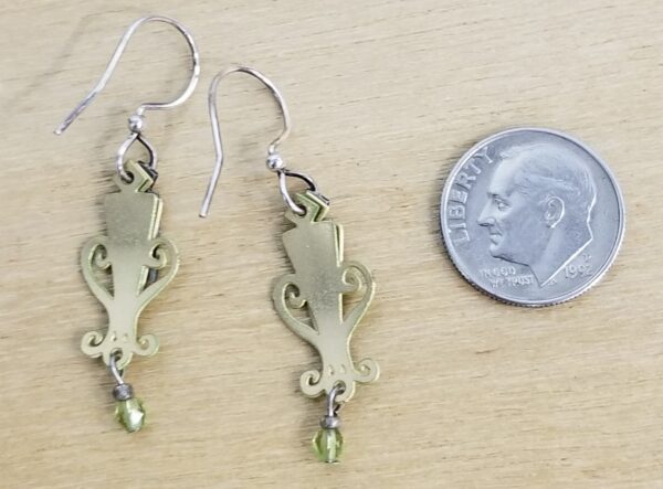 Back of green earrings with dime for scale
