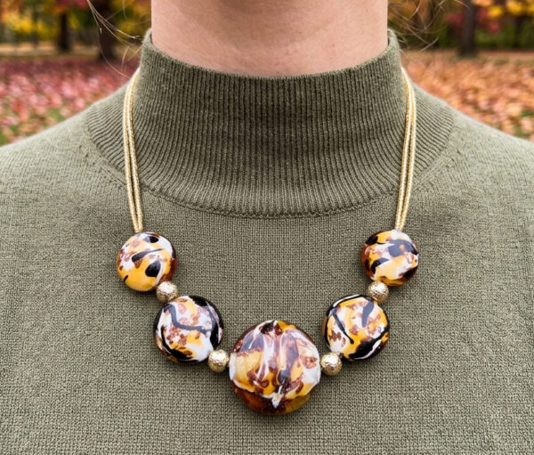 close-up of brown Murano glass necklace on model