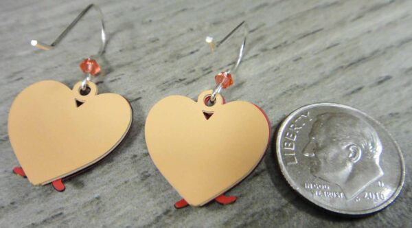 backside of cat in heart earrings with dime for size comparison