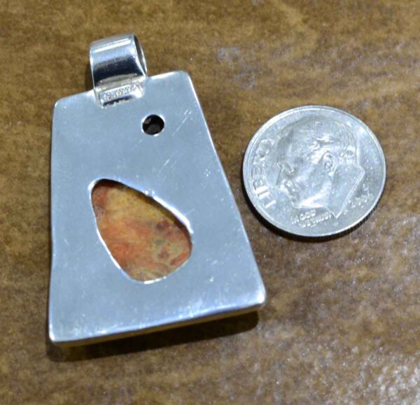 back of coral pendant with dime for size