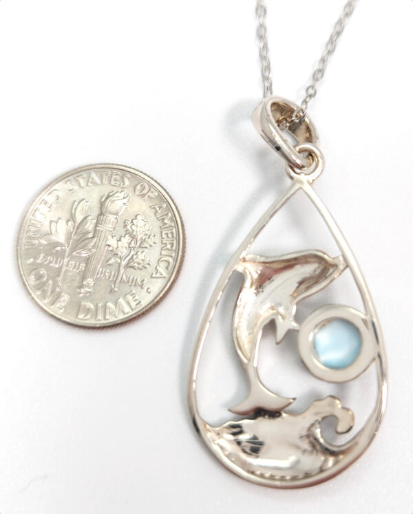 Backside of dolphin pendant with dime for size comparison