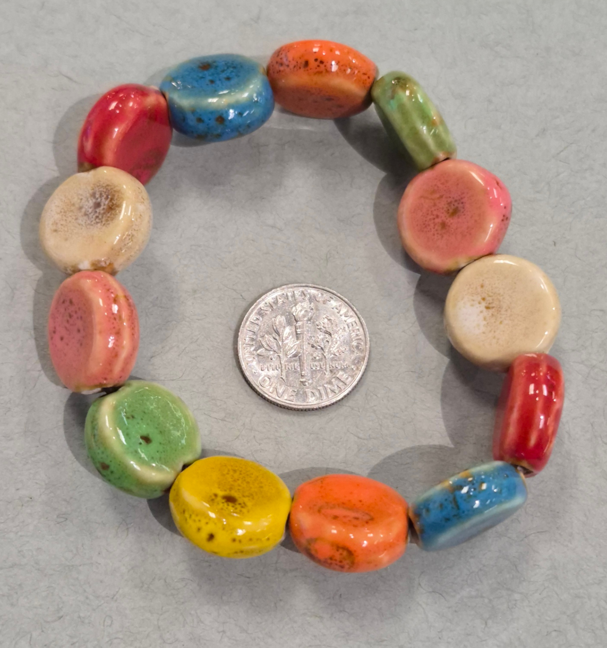 multicolor flat circle ceramic beaded bracelet with dime for size comparison