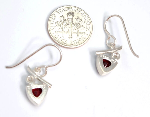 Backside of garnet and pearl earrings with dime for size comparison