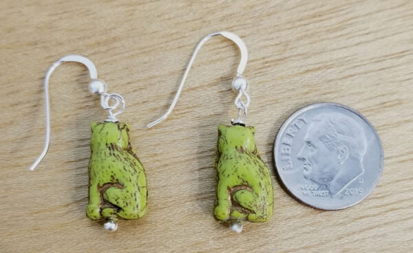 back of bright green Czech glass cat earrings with dime for scale