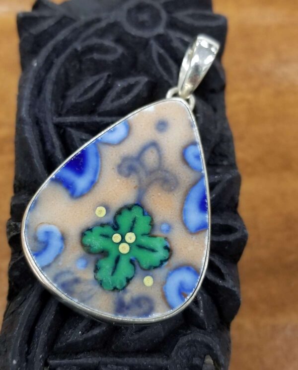 green, blue, and tan ceramic pendant