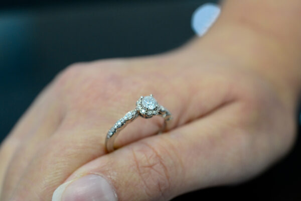 halo diamond engagement ring in hand