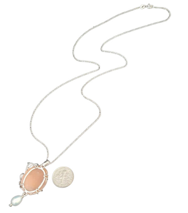 backside of cameo necklace with dime for size comparison