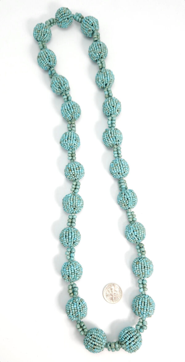 light blue necklace with dime for size comparison