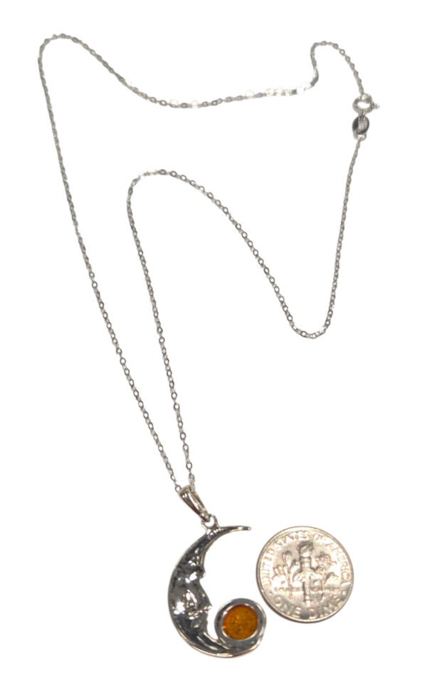 backside of man in the moon necklace with dime for size comparison