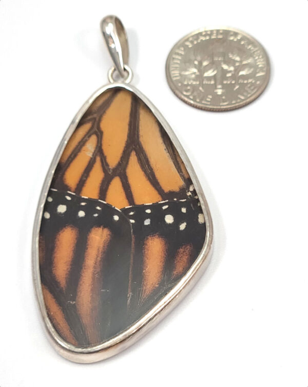 backside of monarch butterfly pendant with dime to show size