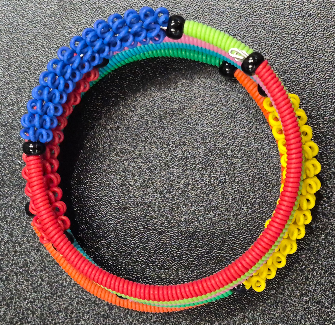 top view of multicolor repurposed telephone wire spiral bracelet in multicolor