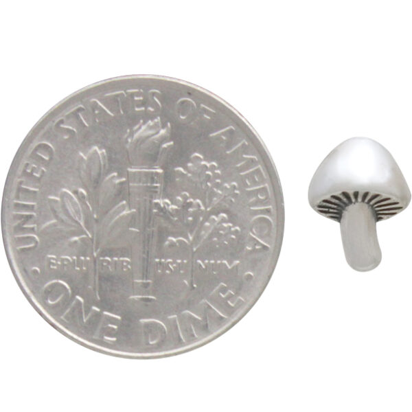 mushroom earring next to dime to help show scale