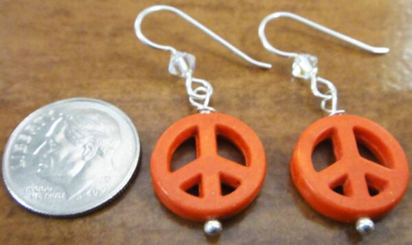 handmade orange peace sign earrings with dime for size
