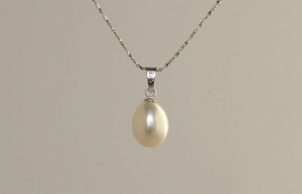 Close up of back of pearl pendant, to show metal marking indicating the necklace is silver