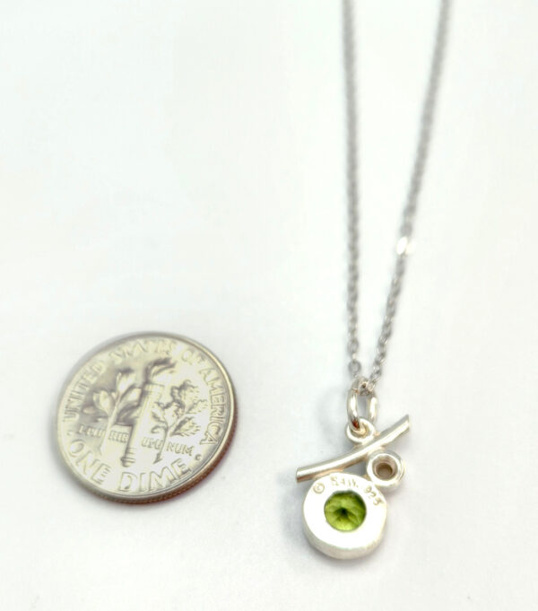 Backside of peridot and pearl necklace with dime for size comparison