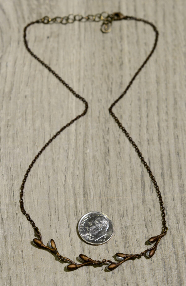 Back view of Michael Michaud's pussy willow necklace, shown with dime (not included) for scale