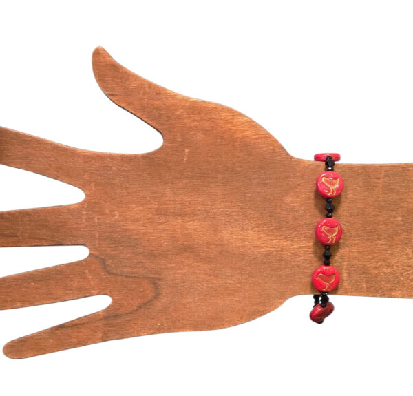 red bird bracelet on wooden hand form