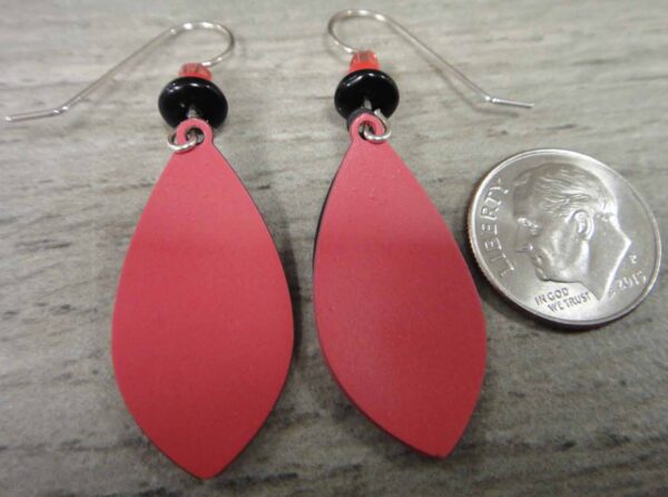 back of red and black earrings with dime for scale