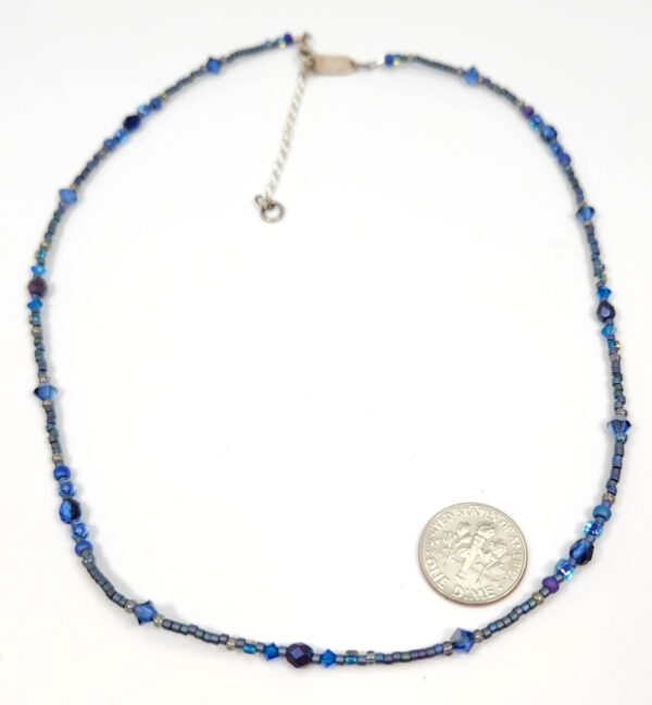 Dainty beaded necklace in dark blue by Holly Yashi with dime for size comparison