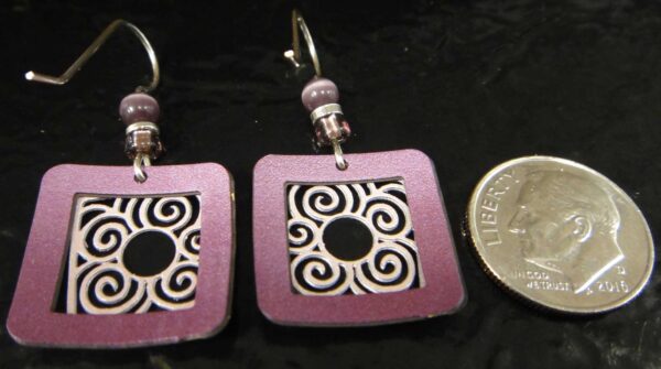 backside of purple earrings with dime for size comparison