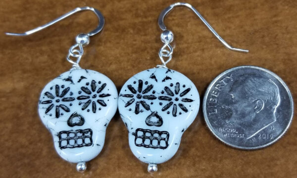sugar skull earrings with dime for scale