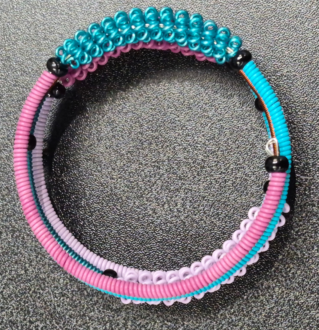top view of telephone wire bracelet in peacock color