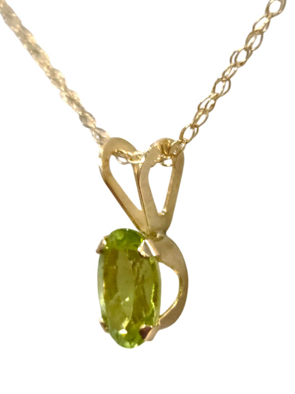 side view of tiny peridot pendant on 18 inch gold chain