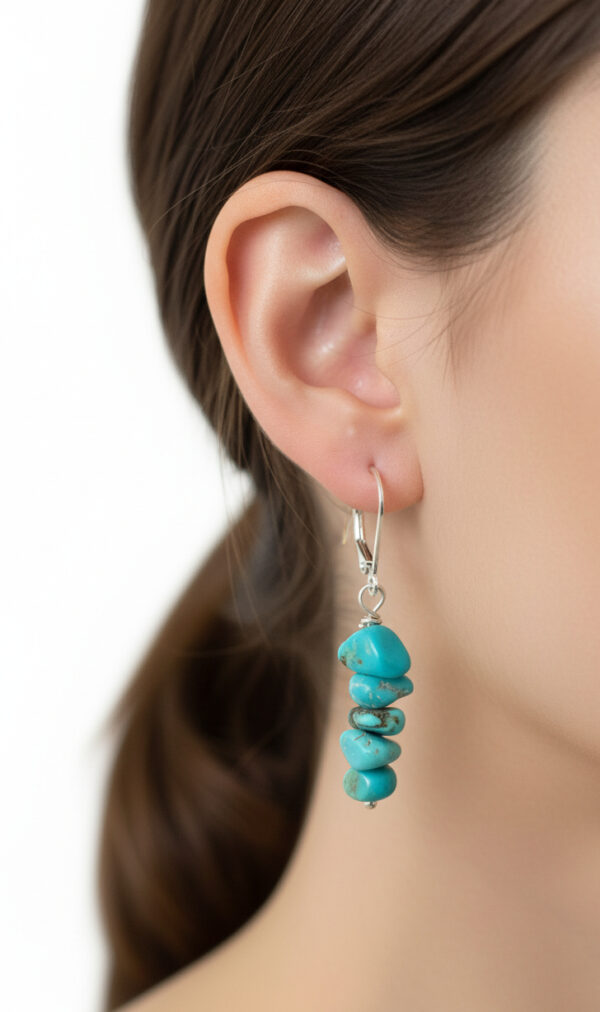close-up of turquoise earrings on model