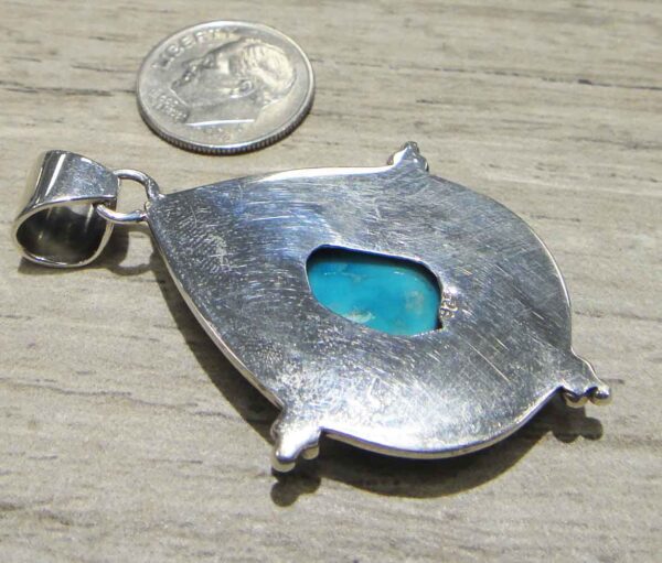 back of turquoise hand hammered sterling silver pendant with dime for scale