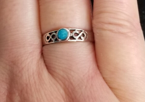Turquoise infinity ring on hand