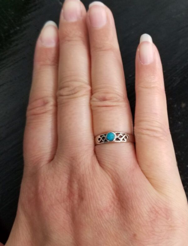 turquoise infinity ring on hand
