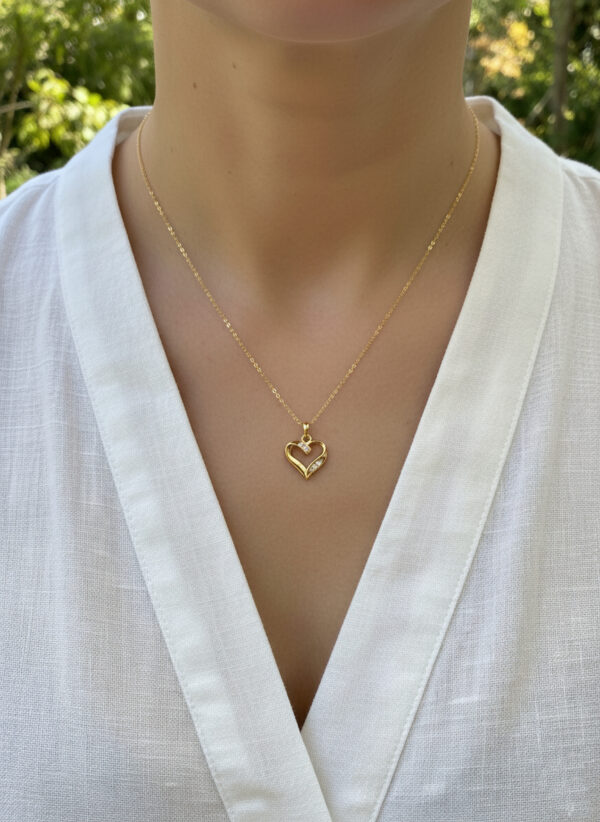 dainty diamond and gold heart necklace on model