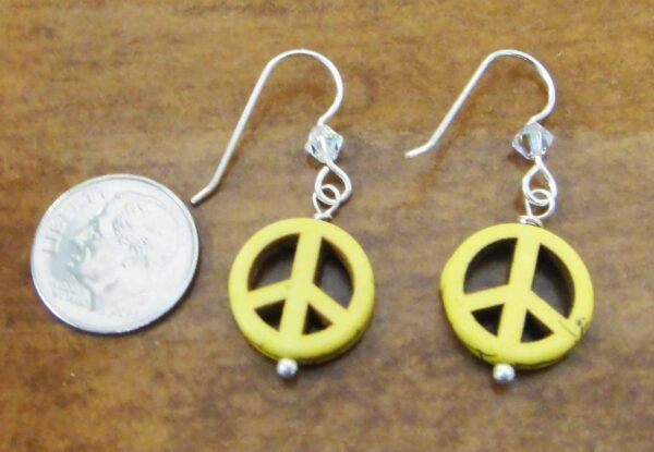 yellow peace sign earrings with dime for size