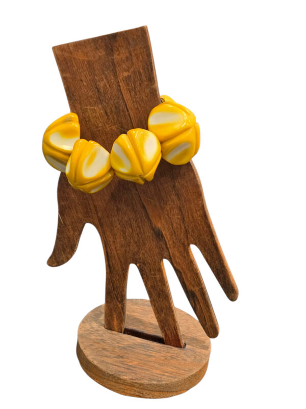yellow tagua nut bracelet on wooden hand form